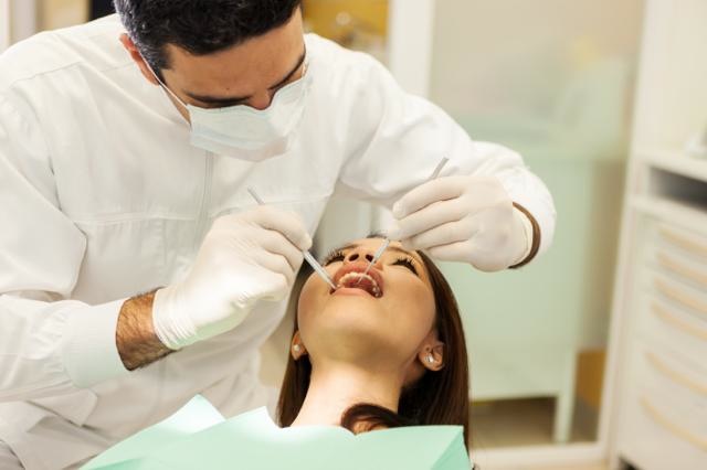 caucasian dentist is visiting an asian woman