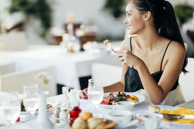 BM_Beautiful woman eating meal in restaurant_93172999